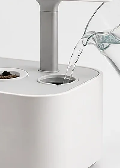 Eau versée dans l’ouverture du réservoir, au pied du bras de la lampe
